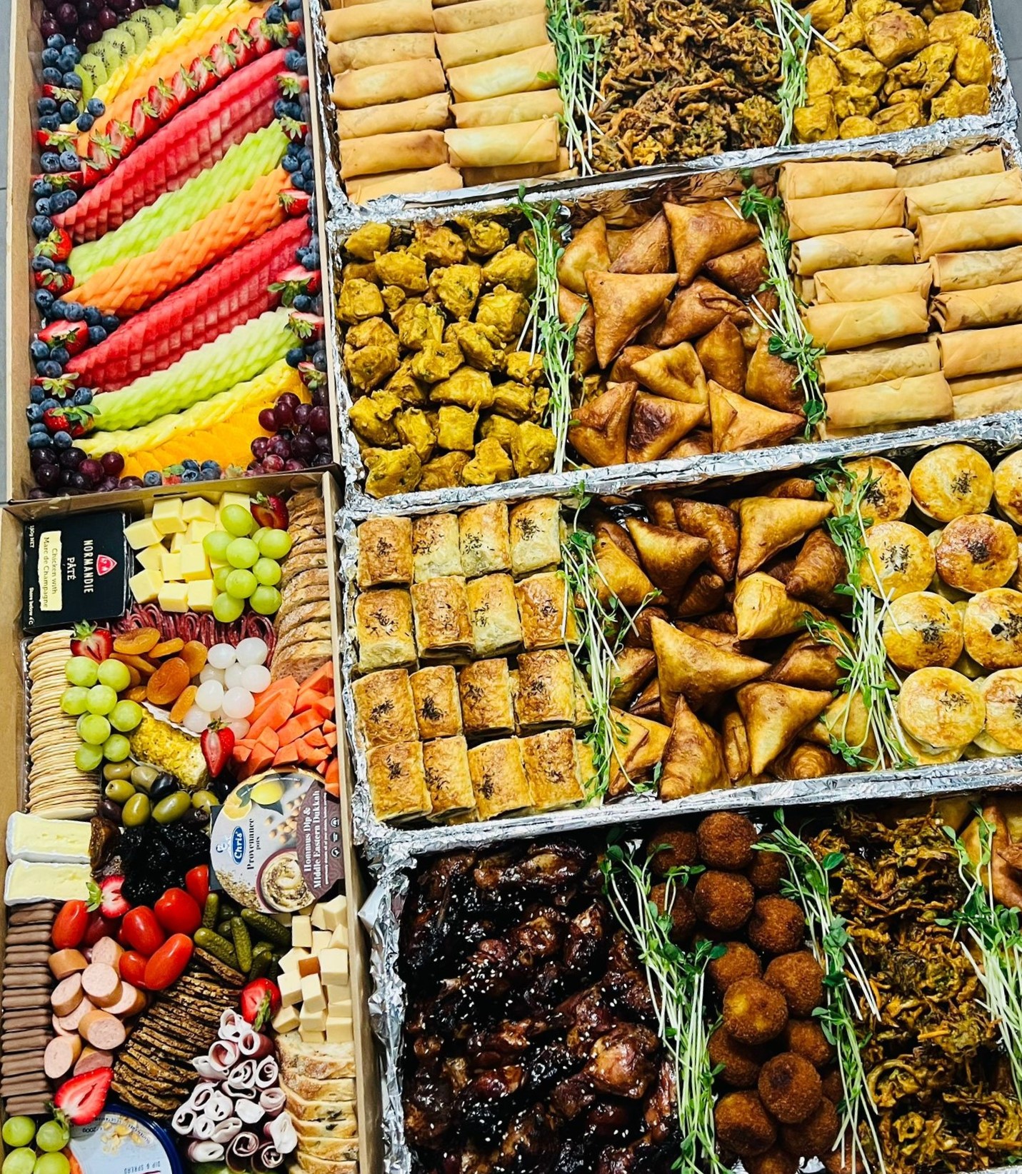 A lavish spread of Christine's catering — fruit, grazing, samosas, spring rolls, pastries and wings